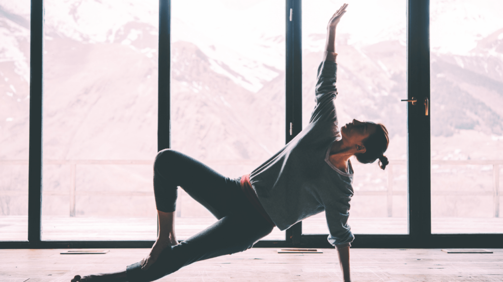 Woman in yoga pose for her health with mountains in background 