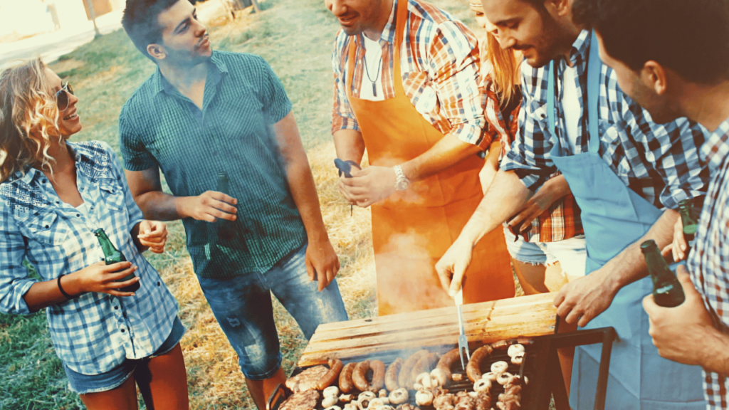 Young men and women reduce stress by cooking around a campfire grill.