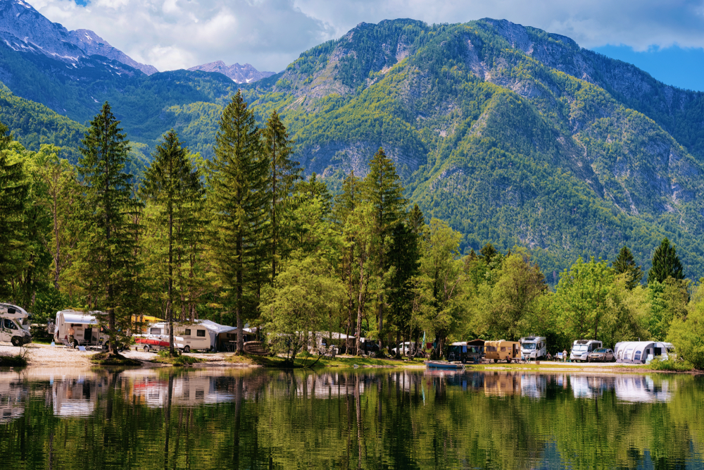 An RV resort on the edge of a lake at the foot of the mountains.